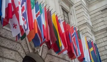 Group of different flags hanging on building
